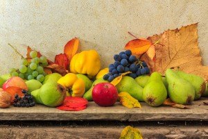Autumnal Still Life With Fruit And Leaves On A Wooden Base