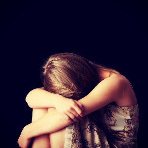 Young woman depression isolated on black background