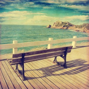 Image of bench near the ocean in vintage style.