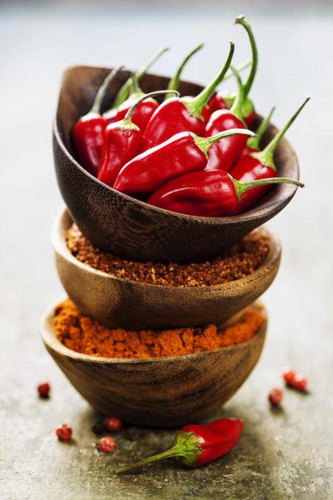 Red Hot Chili Peppers with herbs and spices over wooden backgrou