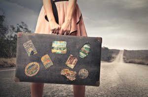 young woman with a vintage suitcase in the middle of a deserted