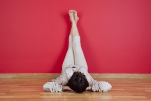 woman laying on the floor of her house next to a red wall